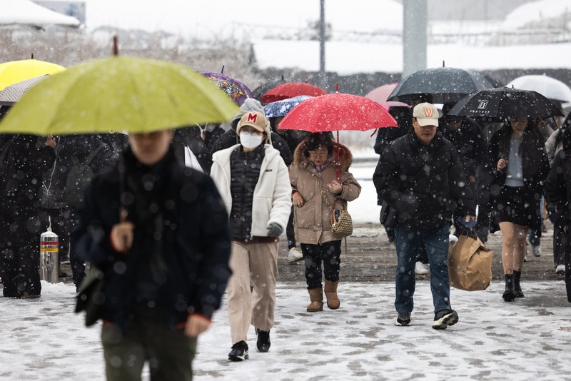 Visitors wearing traditional hanbok dress walk in the snow at Gyeongbokgung palace in central Seoul on December 30, 2023. Visitors wearing traditional hanbok dress walk in the snow at Gyeongbokgung palace in central Seoul on December 30, 2023. (JUNG YEON-JE/AFP via Getty Images)