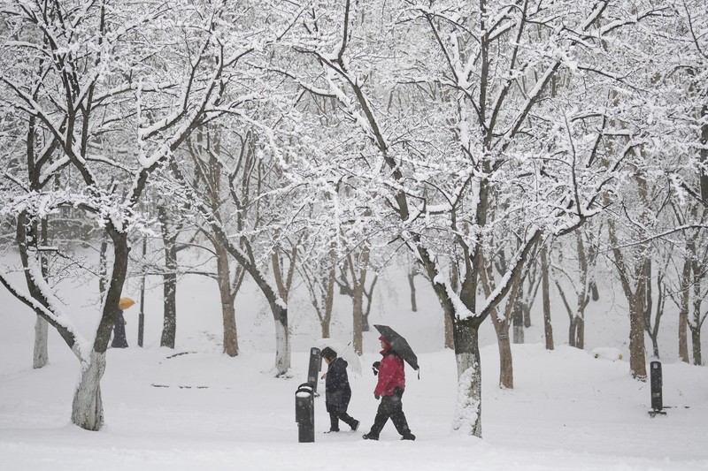 Visitors wearing traditional hanbok dress walk in the snow at Gyeongbokgung palace in central Seoul on December 30, 2023. Visitors wearing traditional hanbok dress walk in the snow at Gyeongbokgung palace in central Seoul on December 30, 2023. (JUNG YEON-JE/AFP via Getty Images)