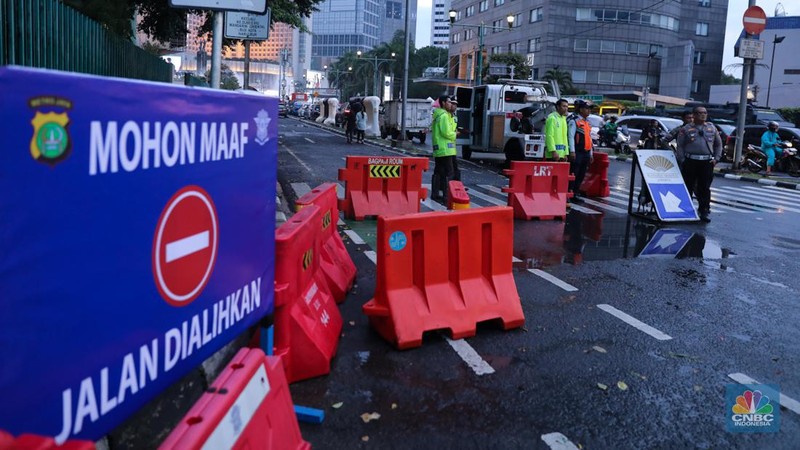 Petugas gabungan melakukan penutupan jalan di kawasan Bundaran Hotel Indonesia (HI), Jakarta, Minggu (31/12/2023). (CNBC Indonesia/Faisal Rahman)