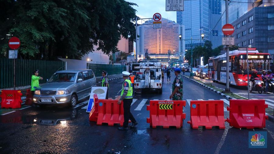 Petugas gabungan melakukan penutupan jalan di kawasan Bundaran Hotel Indonesia (HI), Jakarta, Minggu (31/12/2023). (CNBC Indonesia/Faisal Rahman)