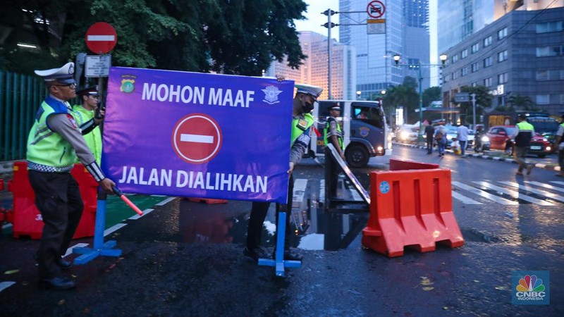 Petugas gabungan melakukan penutupan jalan di kawasan Bundaran Hotel Indonesia (HI), Jakarta, Minggu (31/12/2023). (CNBC Indonesia/Faisal Rahman)