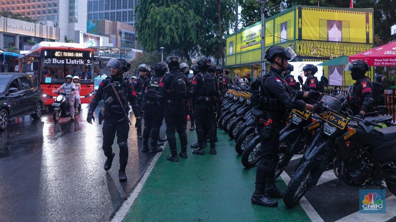 Petugas gabungan melakukan penutupan jalan di kawasan Bundaran Hotel Indonesia (HI), Jakarta, Minggu (31/12/2023). (CNBC Indonesia/Faisal Rahman)