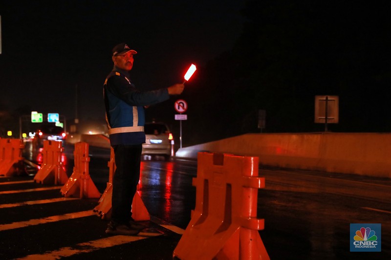 Petugas Jasa Marga sedang melakukan pengalihan arus kendaraan di Simpang Polingga KM 46 Tol Jagorawi, pintu GT Ciawi, Kabupaten Bogor, Jawa Barat, Sabtu (31/12/2022). (CNBC Indonesia/Muhammad Sabki)