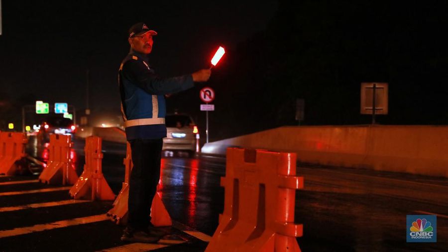 Petugas Jasa Marga sedang melakukan pengalihan arus kendaraan di Simpang Polingga KM 46 Tol Jagorawi, pintu GT Ciawi, Kabupaten Bogor, Jawa Barat, Sabtu (31/12/2022). (CNBC Indonesia/Muhammad Sabki)