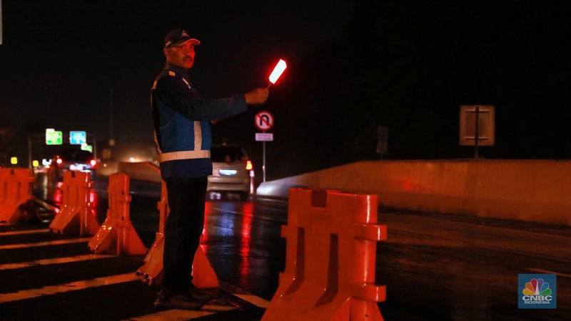 Petugas Jasa Marga sedang melakukan pengalihan arus kendaraan di Simpang Polingga KM 46 Tol Jagorawi, pintu GT Ciawi, Kabupaten Bogor, Jawa Barat, Sabtu (31/12/2022). (CNBC Indonesia/Muhammad Sabki)