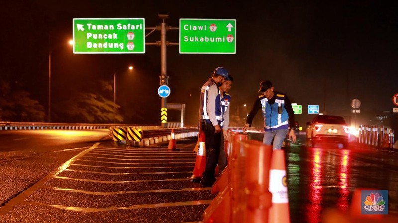 Petugas Jasa Marga sedang melakukan pengalihan arus kendaraan di Simpang Polingga KM 46 Tol Jagorawi, pintu GT Ciawi, Kabupaten Bogor, Jawa Barat, Sabtu (31/12/2022). (CNBC Indonesia/Muhammad Sabki)