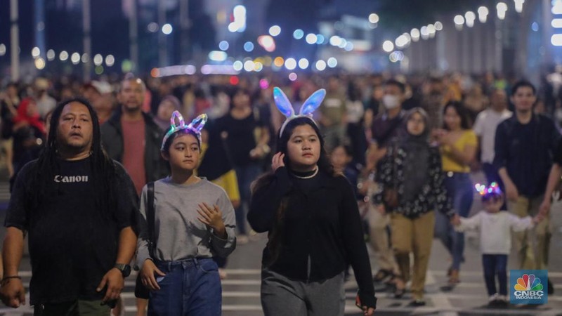 Warga memadati Car Free Night (CFN) perayaan malam Tahun Baru 2024 di kawasan Bundaran Hotel Indonesia (HI), Jakarta, Minggu (31/12/2023). (CNBC Indonesia/Faisal Rahman)
