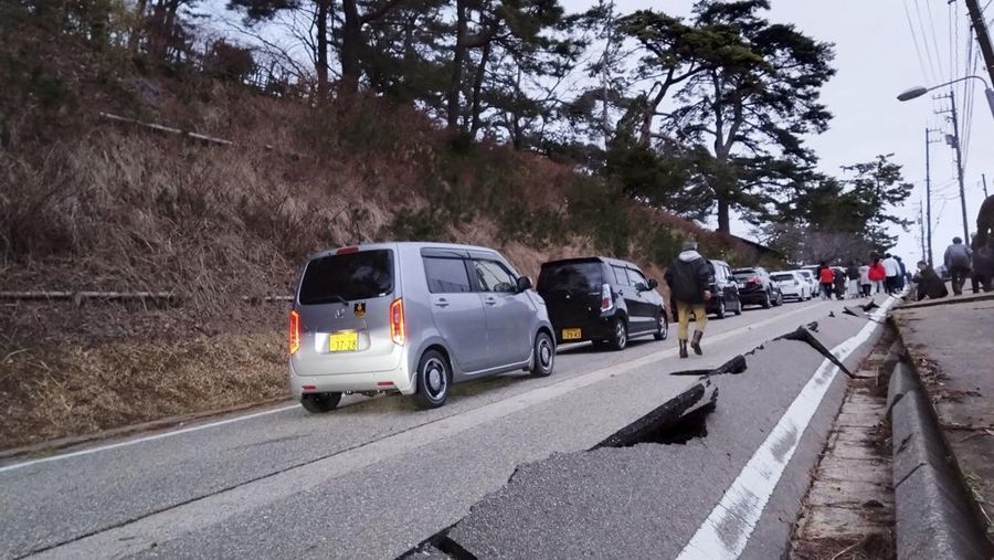 Orang-orang berjalan di sepanjang jalan yang rusak akibat gempa, di Wajima, prefektur Ishikawa, Jepang 1 Januari 2024, dalam gambar yang dirilis oleh Kyodo. (Mandatory credit Kyodo via REUTERS)