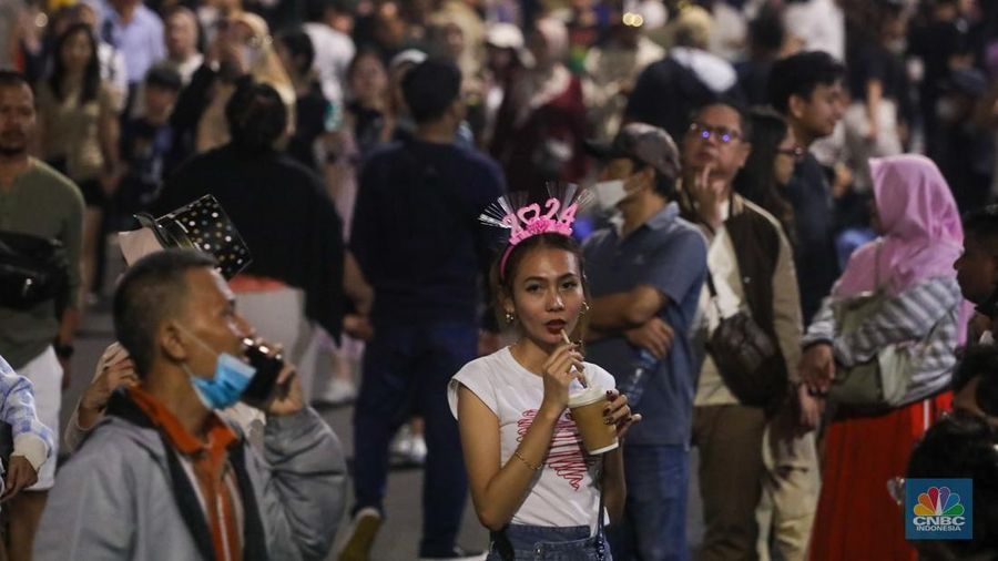 Warga menyaksikan atraksi drone saat Car Free Night (CFN) perayaan malam Tahun Baru 2024 di kawasan Bundaran Hotel Indonesia (HI), Jakarta, Minggu (31/12/2023). (CNBC Indonesia/Faisal Rahman)