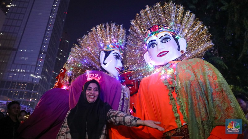 Warga menyaksikan atraksi drone saat Car Free Night (CFN) perayaan malam Tahun Baru 2024 di kawasan Bundaran Hotel Indonesia (HI), Jakarta, Minggu (31/12/2023). (CNBC Indonesia/Faisal Rahman)