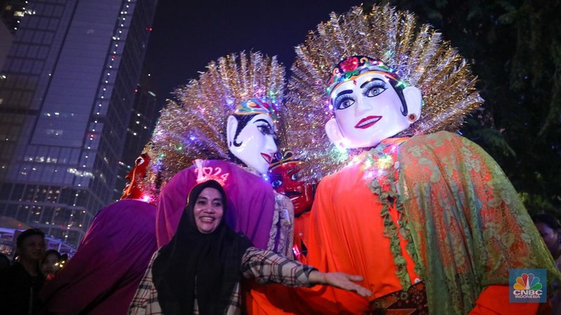 Warga menyaksikan atraksi drone saat Car Free Night (CFN) perayaan malam Tahun Baru 2024 di kawasan Bundaran Hotel Indonesia (HI), Jakarta, Minggu (31/12/2023). (CNBC Indonesia/Faisal Rahman)
