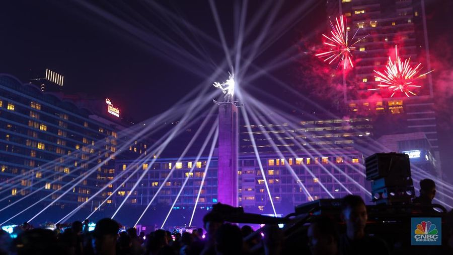 Warga menyaksikan atraksi drone saat Car Free Night (CFN) perayaan malam Tahun Baru 2024 di kawasan Bundaran Hotel Indonesia (HI), Jakarta, Minggu (31/12/2023). (CNBC Indonesia/Faisal Rahman)