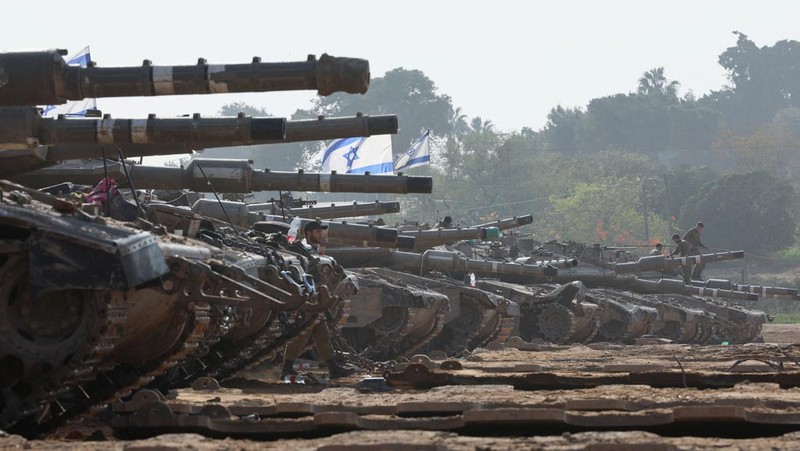 An Israeli soldier walks by tanks, amid the ongoing conflict between Israel and the Palestinian Islamist group Hamas, near the Israel-Gaza border, in southern Israel, January 1, 2024. REUTERS/Violeta Santos Moura