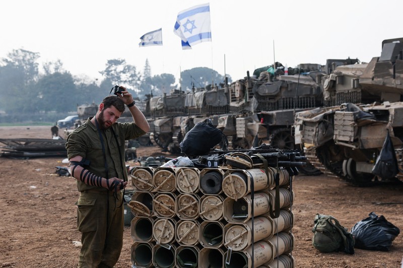 ISRAEL-PALESTINIANS/ An Israeli soldier walks by tanks, amid the ongoing conflict between Israel and the Palestinian Islamist group Hamas, near the Israel-Gaza border, in southern Israel, January 1, 2024. REUTERS/Violeta Santos Moura
