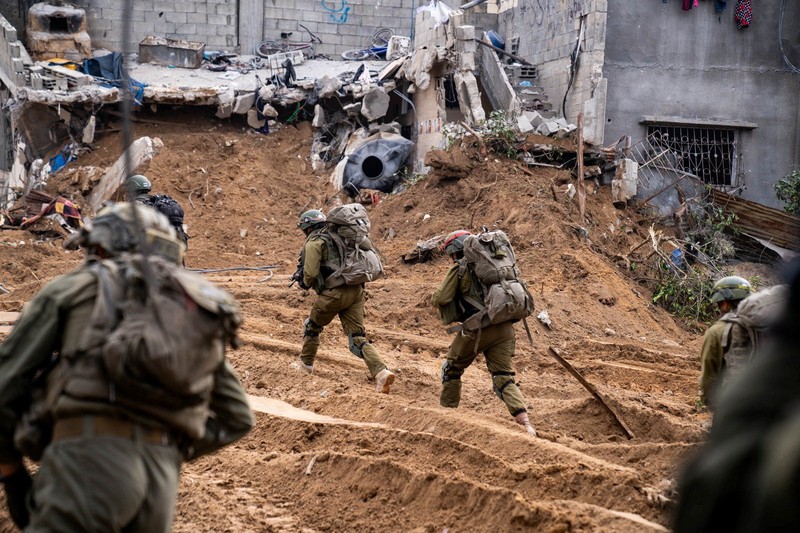 An Israeli soldier walks by tanks, amid the ongoing conflict between Israel and the Palestinian Islamist group Hamas, near the Israel-Gaza border, in southern Israel, January 1, 2024. REUTERS/Violeta Santos Moura