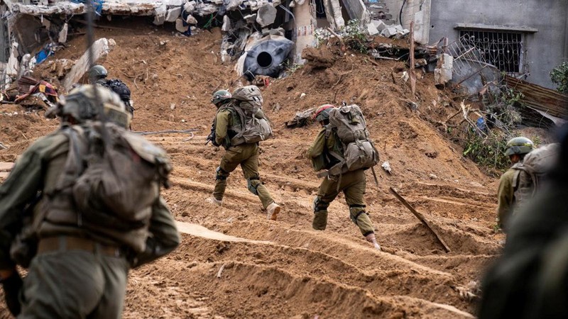 An Israeli soldier walks by tanks, amid the ongoing conflict between Israel and the Palestinian Islamist group Hamas, near the Israel-Gaza border, in southern Israel, January 1, 2024. REUTERS/Violeta Santos Moura