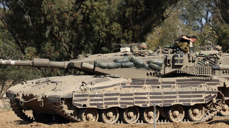 An Israeli soldier walks by tanks, amid the ongoing conflict between Israel and the Palestinian Islamist group Hamas, near the Israel-Gaza border, in southern Israel, January 1, 2024. REUTERS/Violeta Santos Moura