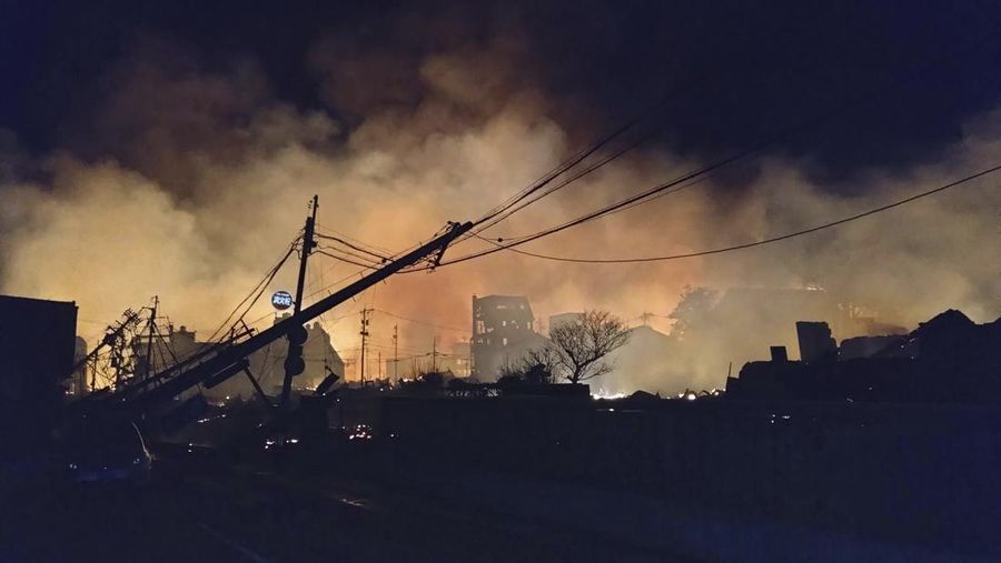 Japan Earthquake Smoke rises at the site of a fire occurred following an earthquake in Wajima, Ishikawa prefecture, Japan Tuesday, Jan. 2, 2024. Japan issued tsunami alerts and told people to evacuate seaside areas after a series of strong quakes on its western coastline Monday. (Kyodo News via AP)