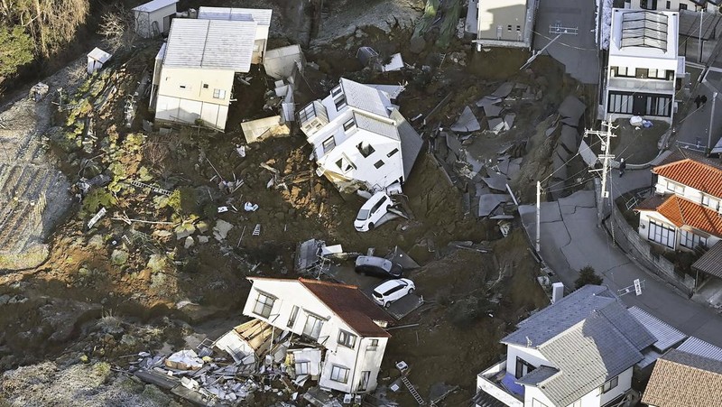 A building falls on the ground following an earthquake in Wajima, Ishikawa prefecture, Japan Tuesday, Jan. 2, 2024. A series of powerful earthquakes in western Japan damaged homes, cars and boats, with officials warning people on Tuesday to stay away from their homes in some areas because of a continuing risk of major quakes and tsunamis. (Kyodo News via AP)
