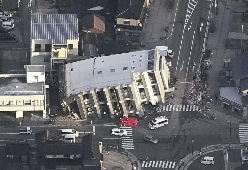 Japan Earthquake A building falls on the ground following an earthquake in Wajima, Ishikawa prefecture, Japan Tuesday, Jan. 2, 2024. A series of powerful earthquakes in western Japan damaged homes, cars and boats, with officials warning people on Tuesday to stay away from their homes in some areas because of a continuing risk of major quakes and tsunamis. (Kyodo News via AP)