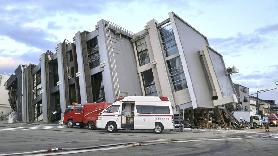 A building falls on the ground following an earthquake in Wajima, Ishikawa prefecture, Japan Tuesday, Jan. 2, 2024. A series of powerful earthquakes in western Japan damaged homes, cars and boats, with officials warning people on Tuesday to stay away from their homes in some areas because of a continuing risk of major quakes and tsunamis. (Kyodo News via AP)