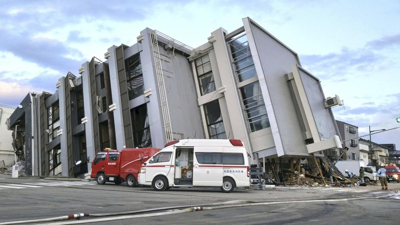 A building falls on the ground following an earthquake in Wajima, Ishikawa prefecture, Japan Tuesday, Jan. 2, 2024. A series of powerful earthquakes in western Japan damaged homes, cars and boats, with officials warning people on Tuesday to stay away from their homes in some areas because of a continuing risk of major quakes and tsunamis. (Kyodo News via AP)