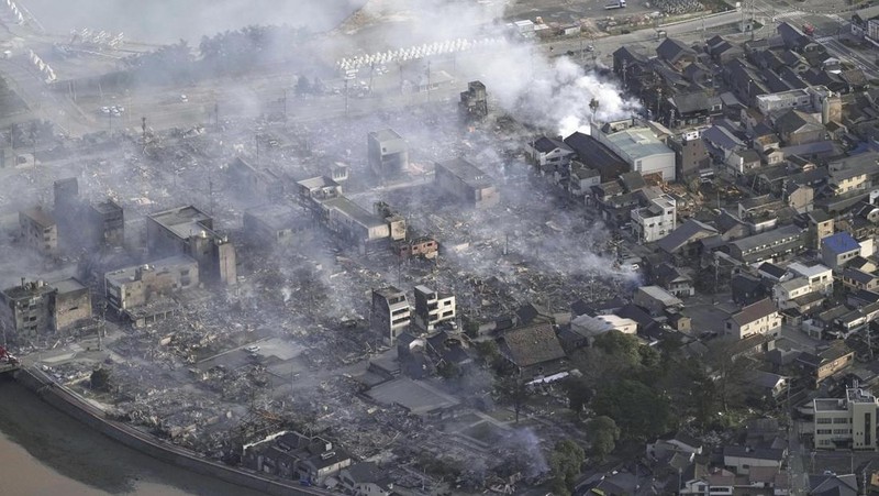 A building falls on the ground following an earthquake in Wajima, Ishikawa prefecture, Japan Tuesday, Jan. 2, 2024. A series of powerful earthquakes in western Japan damaged homes, cars and boats, with officials warning people on Tuesday to stay away from their homes in some areas because of a continuing risk of major quakes and tsunamis. (Kyodo News via AP)