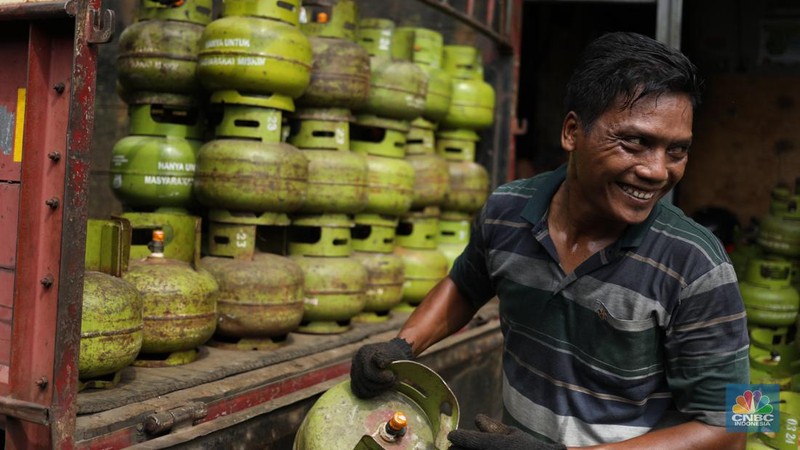Pekerja menurunkan Liquefied Petroleum Gas (LPG) bersubsidi tabung 3 kilogram (kg) dari truk di pangkalan resmi LPG 3 kg Pertamina di Kawasan Jakarta, Selasa (2/1/2024). (CNBC Indonesia/Tri Susilo)