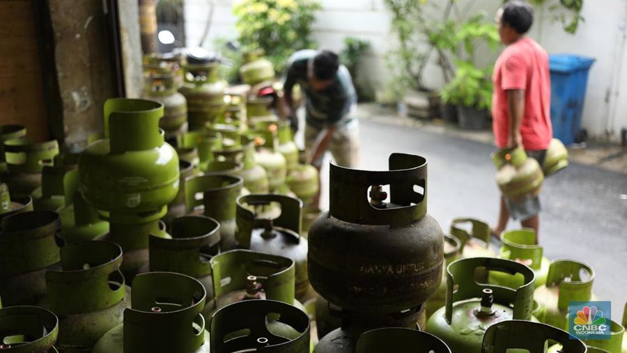 Pekerja menurunkan Liquefied Petroleum Gas (LPG) bersubsidi tabung 3 kilogram (kg) dari truk di pangkalan resmi LPG 3 kg Pertamina di Kawasan Jakarta, Selasa (2/1/2024). (CNBC Indonesia/Tri Susilo)