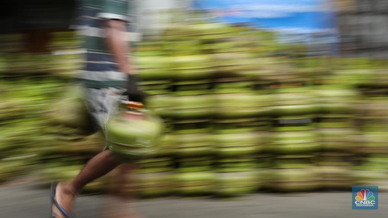 Pekerja menurunkan Liquefied Petroleum Gas (LPG) bersubsidi tabung 3 kilogram (kg) dari truk di pangkalan resmi LPG 3 kg Pertamina di Kawasan Jakarta, Selasa (2/1/2024). (CNBC Indonesia/Tri Susilo)
