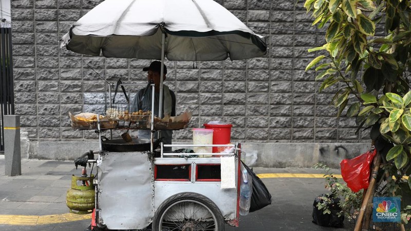 Pekerja menurunkan Liquefied Petroleum Gas (LPG) bersubsidi tabung 3 kilogram (kg) dari truk di pangkalan resmi LPG 3 kg Pertamina di Kawasan Jakarta, Selasa (2/1/2024). (CNBC Indonesia/Tri Susilo)