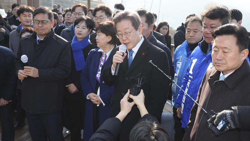 South Korean opposition leader Lee Jae-myung, center, speaks as he visits the construction site of a new airport in Busan, South Korea, Tuesday, Jan. 2, 2024. Lee was attacked and injured by an unidentified man during a visit Tuesday to the southeastern city of Busan, emergency officials said. (Sohn Hyung-joo/Yonhap via AP)