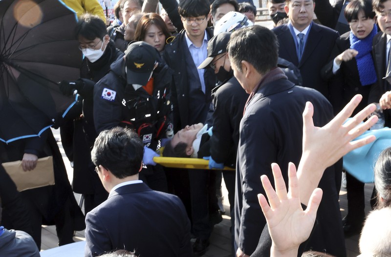 South Korea Politician Attacked South Korean opposition leader Lee Jae-myung, center, speaks as he visits the construction site of a new airport in Busan, South Korea, Tuesday, Jan. 2, 2024. Lee was attacked and injured by an unidentified man during a visit Tuesday to the southeastern city of Busan, emergency officials said. (Sohn Hyung-joo/Yonhap via AP)