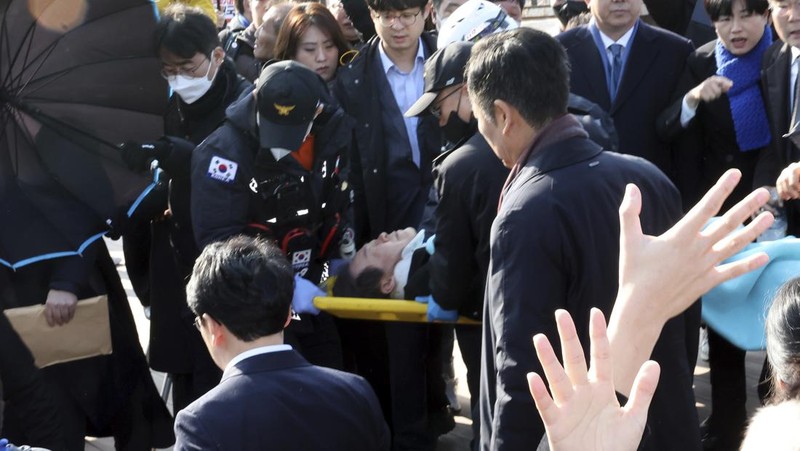 South Korean opposition leader Lee Jae-myung, center, speaks as he visits the construction site of a new airport in Busan, South Korea, Tuesday, Jan. 2, 2024. Lee was attacked and injured by an unidentified man during a visit Tuesday to the southeastern city of Busan, emergency officials said. (Sohn Hyung-joo/Yonhap via AP)