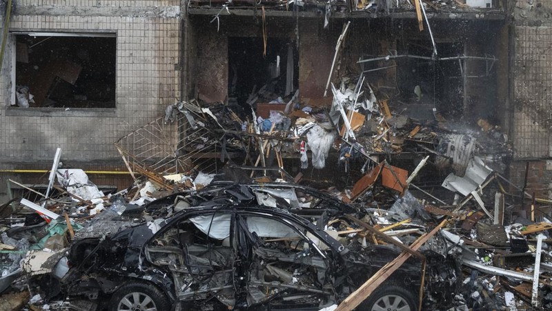 Petugas pemadam kebakaran berupaya memadamkan api di gedung apartemen yang hancur pasca serangan Rusia di Kyiv, Ukraina, Selasa, 2 Januari 2024. (AP Photo/Efrem Lukatsky)
