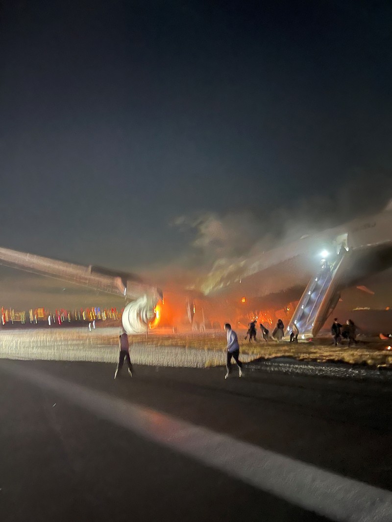 JAPAN-AIRPORT/FIRE People sit amid smoke inside the Japan Airlines' A350 airplane in this screen grab obtained from social media video. Video Obtained by Reuters/via REUTERS THIS IMAGE HAS BEEN SUPPLIED BY A THIRD PARTY.