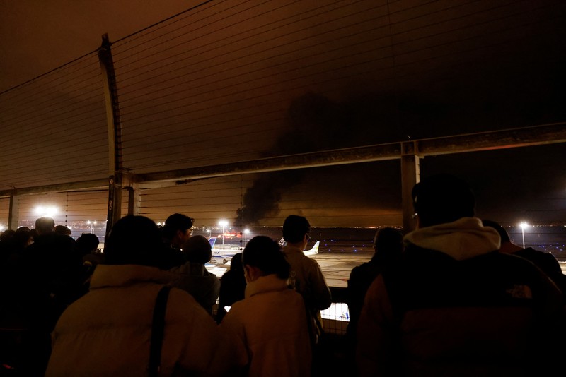 JAPAN-AIRPORT/FIRE People sit amid smoke inside the Japan Airlines' A350 airplane in this screen grab obtained from social media video. Video Obtained by Reuters/via REUTERS THIS IMAGE HAS BEEN SUPPLIED BY A THIRD PARTY.