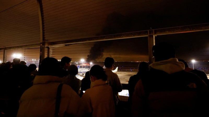 People sit amid smoke inside the Japan Airlines' A350 airplane in this screen grab obtained from social media video. Video Obtained by Reuters/via REUTERS  THIS IMAGE HAS BEEN SUPPLIED BY A THIRD PARTY.