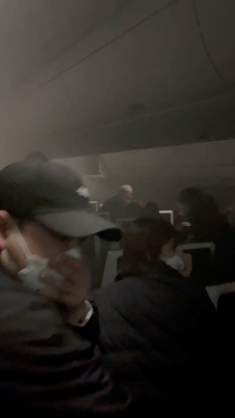 People sit amid smoke inside the Japan Airlines' A350 airplane in this screen grab obtained from social media video. Video Obtained by Reuters/via REUTERS  THIS IMAGE HAS BEEN SUPPLIED BY A THIRD PARTY.
