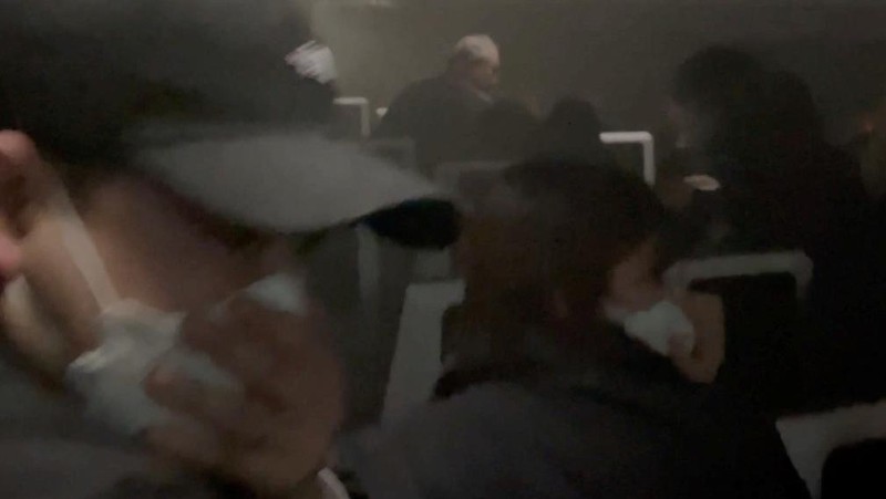 People sit amid smoke inside the Japan Airlines' A350 airplane in this screen grab obtained from social media video. Video Obtained by Reuters/via REUTERS  THIS IMAGE HAS BEEN SUPPLIED BY A THIRD PARTY.