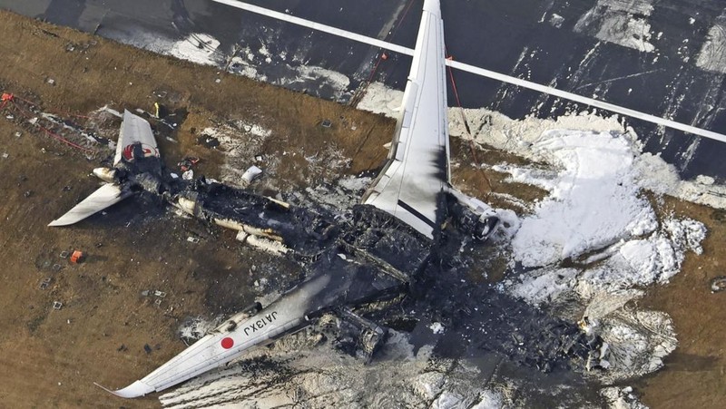This aerial photo show the burn-out Japan Airlines plane at Haneda airport on Wednesday, Jan. 3, 2024, in Tokyo, Japan. The large passenger plane and a Japanese coast guard aircraft collided on the runway at Tokyo's Haneda Airport on Tuesday and burst into flames, killing several people aboard the coast guard plane, officials said. (Kyodo News via AP)