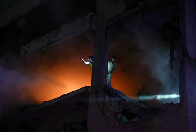 LEBANON-BLAST/ People gather near a damaged site following an explosion, in what security sources say is an Israeli drone strike, at the Beirut suburb of Dahiyeh, Lebanon January 2, 2024. REUTERS/Mohamed Azakir