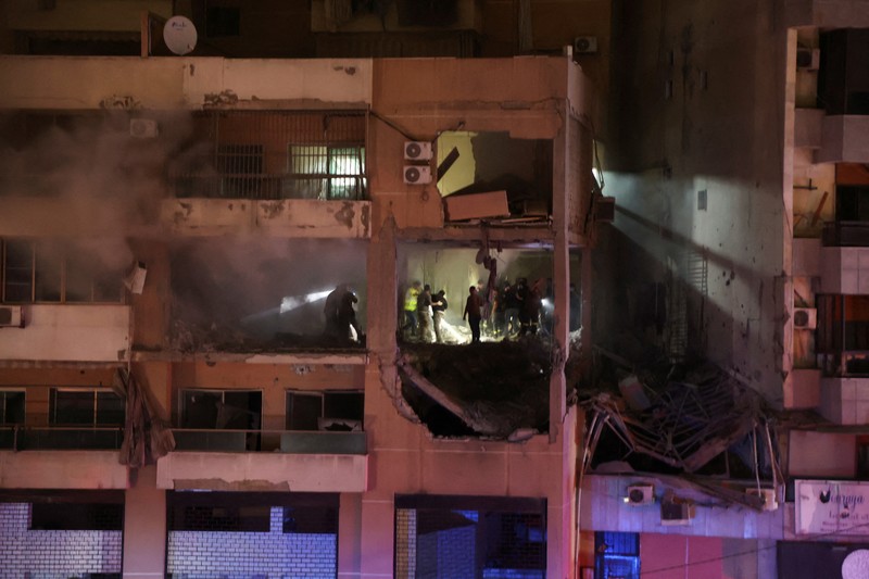 LEBANON-BLAST/ People gather near a damaged site following an explosion, in what security sources say is an Israeli drone strike, at the Beirut suburb of Dahiyeh, Lebanon January 2, 2024. REUTERS/Mohamed Azakir