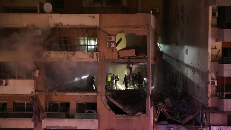 People gather near a damaged site following an explosion, in what security sources say is an Israeli drone strike, at the Beirut suburb of Dahiyeh, Lebanon January 2, 2024. REUTERS/Mohamed Azakir
