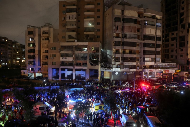 LEBANON-BLAST/ People gather near a damaged site following an explosion, in what security sources say is an Israeli drone strike, at the Beirut suburb of Dahiyeh, Lebanon January 2, 2024. REUTERS/Mohamed Azakir