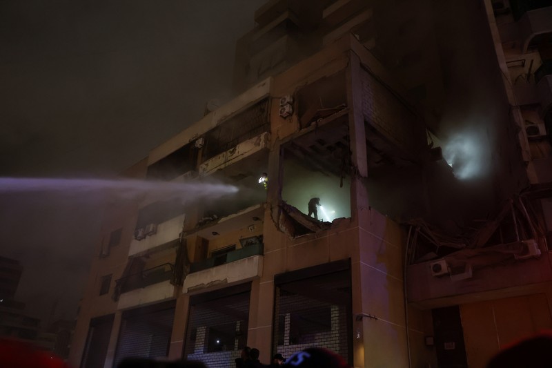 LEBANON-BLAST/ People gather near a damaged site following an explosion, in what security sources say is an Israeli drone strike, at the Beirut suburb of Dahiyeh, Lebanon January 2, 2024. REUTERS/Mohamed Azakir