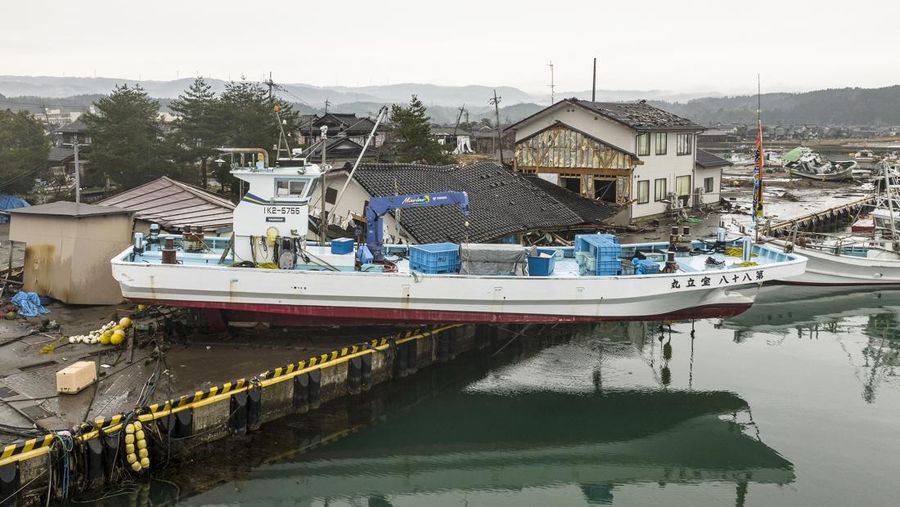 Sebuah kapal terdampar di pantai di kota Suzu, prefektur Ishikawa pada 3 Januari 2024, setelah gempa bumi besar berkekuatan 7,5 melanda wilayah Noto di prefektur Ishikawa pada Hari Tahun Baru. Tim penyelamat Jepang bergegas mencari korban selamat pada 3 Januari ketika pihak berwenang memperingatkan akan terjadinya tanah longsor dan hujan lebat setelah gempa bumi dahsyat yang menewaskan sedikitnya 62 orang. (Photo by FRED MERY/AFP via Getty Images)