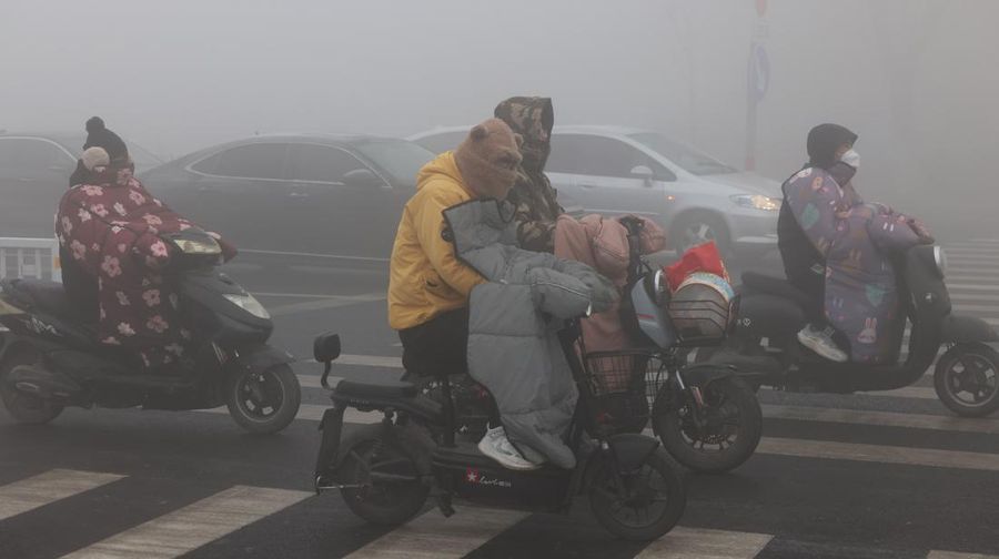 Warga berkendara saat kabut tebal dan udara yang tercemar di Jalan Wenhua Barat di Zaozhuang, Tiongkok, pada 3 Januari 2024.(Photo by Costfoto/NurPhoto via Getty Images)