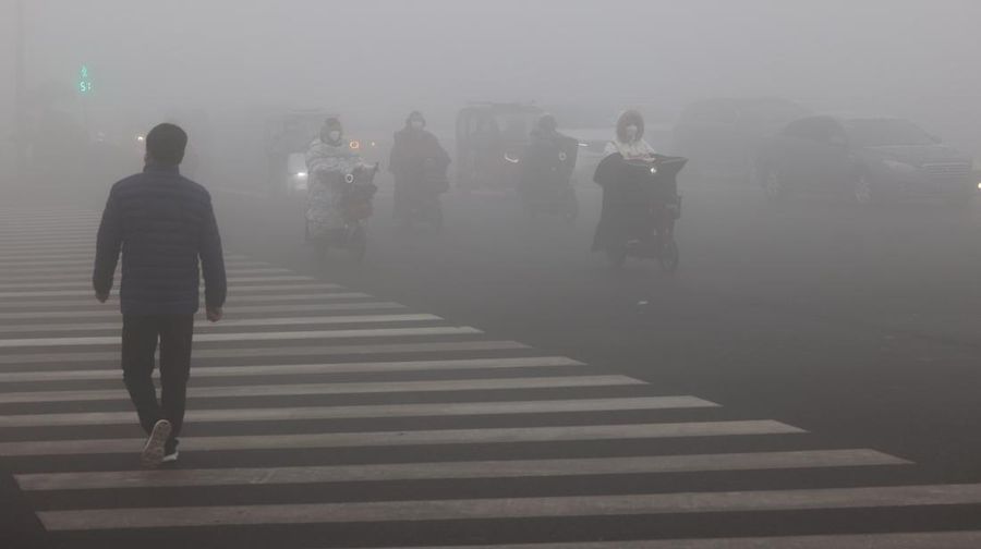 ZAOZHUANG, CHINA - JANUARY 3, 2024 - People ride in heavy fog polluted air on Wenhua West Road in Zaozhuang city, East China's Shandong province, Jan 3, 2024. (Photo credit should read CFOTO/Future Publishing via Getty Images)