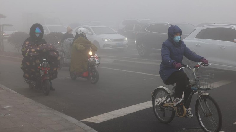 Warga berkendara saat kabut tebal dan udara yang tercemar di Jalan Wenhua Barat di Zaozhuang, Tiongkok, pada 3 Januari 2024.(Photo by Costfoto/NurPhoto via Getty Images)